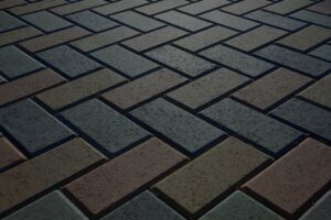 Background - colorful cobblestone pavement of the new paving stones. Diminishing perspective. Backlight.