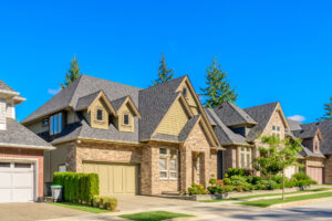 A row of modern suburban homes under a clear blue sky.