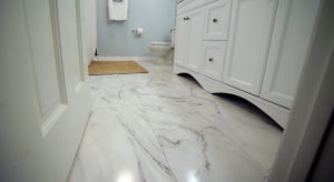 White bathroom with ceramic tile that looks like marble