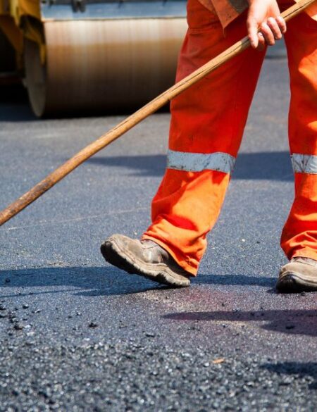 man laying asphalt pavement