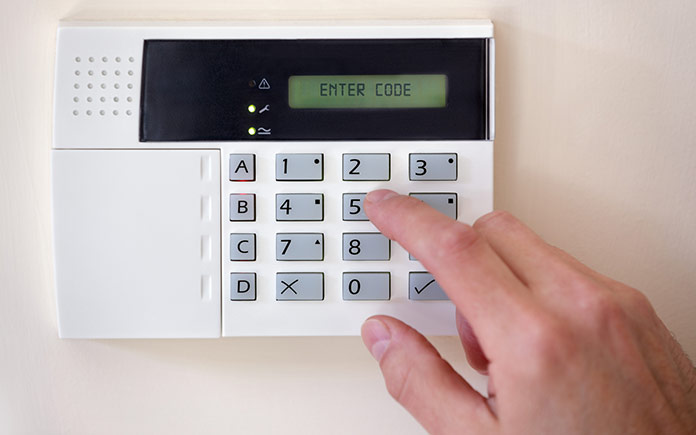 Finger pressing a key on a wireless home security system's keypad