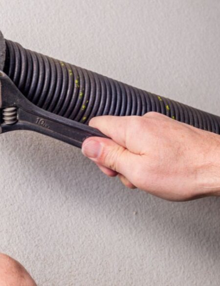 man adjusting door spring
