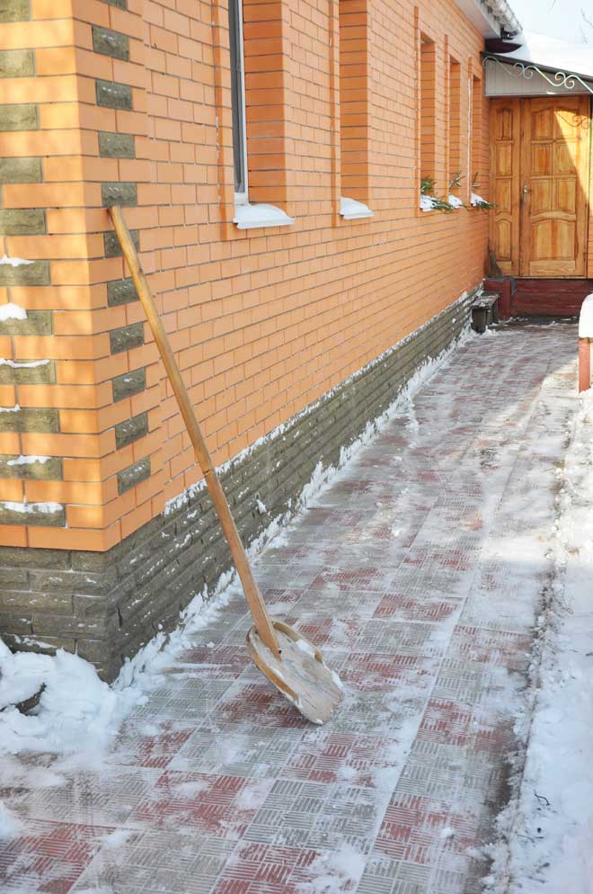 Walkway with ice and a snow shovel.