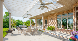 Photo of a concrete patio with patio furniture on it and an awning with a ceiling fan.