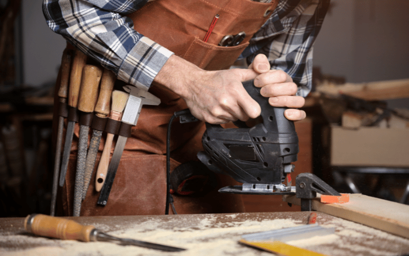 person using a jigsaw to cut wood