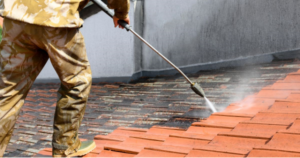A roofing contractor cleaning metal tile