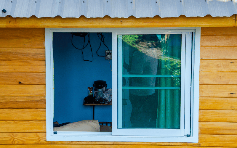 Wood home with slider windows opening into a blue room