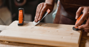 someone applying wood glue to a board